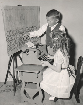 Unidentified students practicing the Bond Skeen Typing Program, using the wall chart and modified fingering developed by Bond.