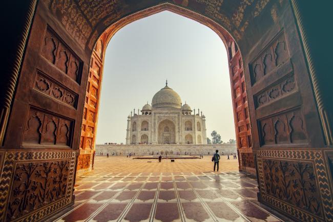 A photo of the Taj Mahal through an arch.