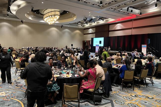 Crowded banquet hall with attendees and awardees at NAME conference