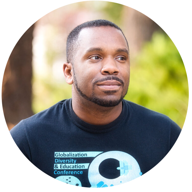 Headshot of Amir Gilmore, wearing a shirt that says "globalization, diversity & Education conference"