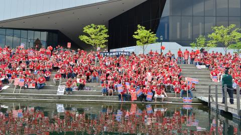 Large group of WEA members sitting outside all in matching red shirts.